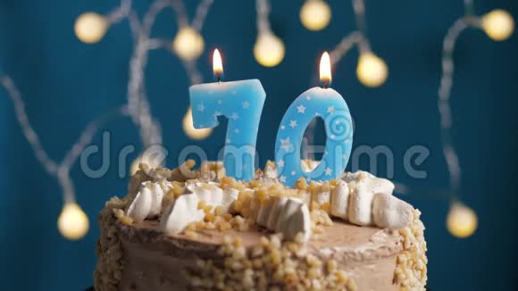 生日蛋糕70号蜡烛在蓝色的背景上蜡烛吹灭了慢动作和特写视频的预览图