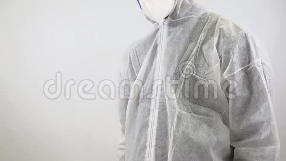 医生穿着全身西装戴着面具用手在白色背景上显示停止标志科罗纳病毒或科维德19全球流行视频的预览图