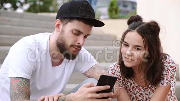 男人和女孩坐在台阶上旁边站着酷酷的滑板车视频的预览图