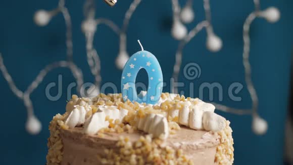 生日蛋糕蓝色背景上有0个数字蜡烛蜡烛吹灭了慢动作和特写视频的预览图