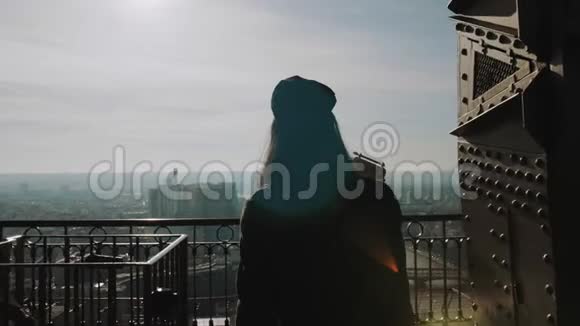 镜头跟随年轻美丽的游客女子摆姿势微笑着在巴黎埃菲尔铁塔上的视角慢动作视频的预览图