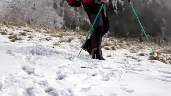 徒步旅行者背着背包走在山岭上覆盖着深深的雪视频的预览图