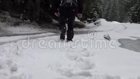 徒步旅行者背着背包走在山岭上覆盖着深深的雪视频的预览图