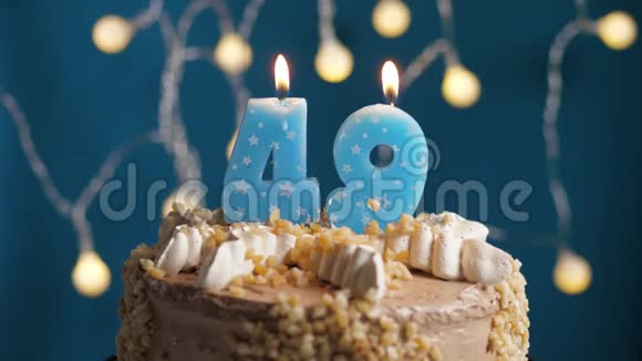 生日蛋糕蓝色背景上有49支蜡烛蜡烛吹灭了慢动作和特写视频的预览图