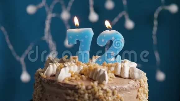 生日蛋糕72号蜡烛在蓝色的背景上蜡烛吹灭了慢动作和特写视频的预览图