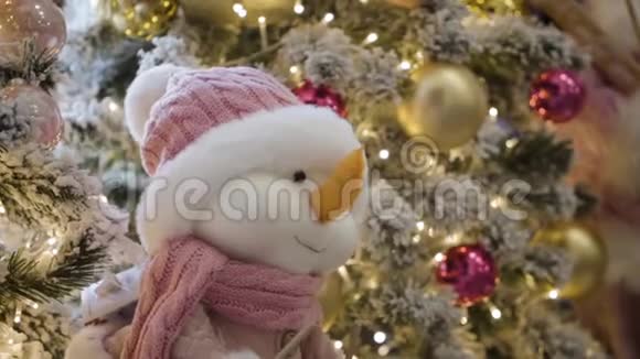 购物中心圣诞树上挂着微笑软玩具的特写可爱的小雪人在装饰之间视频的预览图