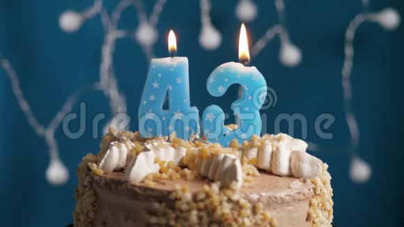 生日蛋糕蓝色背景上有43支蜡烛蜡烛吹灭了慢动作和特写视频的预览图