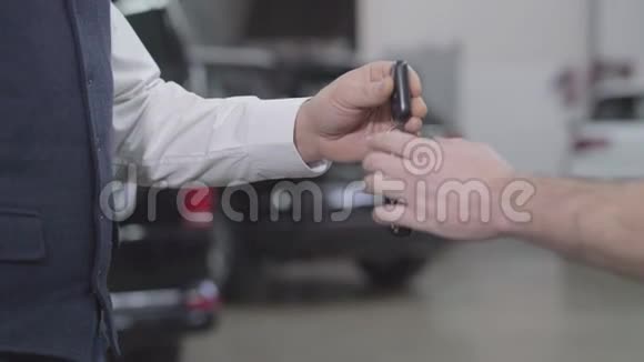特写镜头一名汽车修理工从一个认不出来的男人手里接过汽车钥匙成功的主人视频的预览图