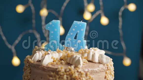 生日蛋糕14个数字燃烧蜡烛由打火机在蓝色的背景蜡烛被点燃了慢速运动和特写镜头视频的预览图