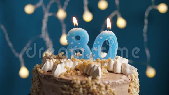 生日蛋糕蓝色背景上有80支蜡烛蜡烛吹灭了慢动作和特写视频的预览图