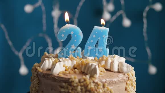 生日蛋糕蓝色背景上有24支蜡烛蜡烛吹灭了慢动作和特写视频的预览图