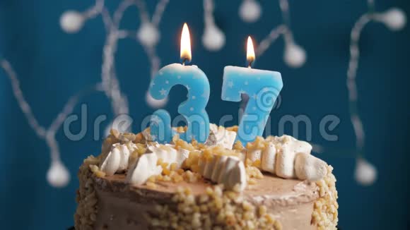 生日蛋糕蓝色背景上有37支蜡烛蜡烛吹灭了慢动作和特写视频的预览图