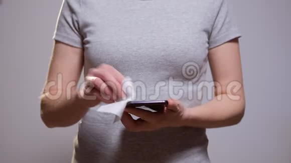一个女人用湿布擦拭她的智能手机上的细菌视频的预览图