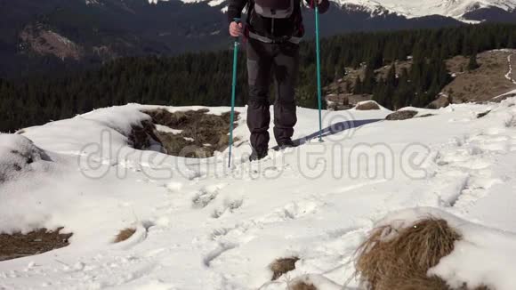 徒步旅行者背着背包走在山岭上覆盖着深深的雪视频的预览图