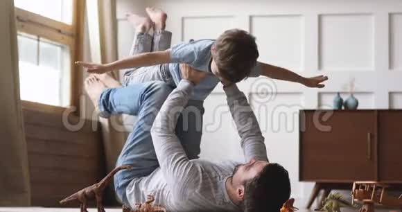 无忧无虑的爸爸举起小儿子假装超级英雄在一起视频的预览图