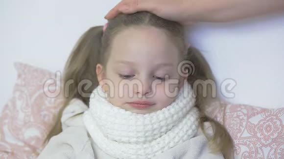 妈妈抚摸着生病的女儿的头照顾孩子感冒和病毒性疾病视频的预览图