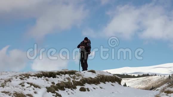 徒步旅行者背着背包走在山岭上覆盖着深深的雪视频的预览图
