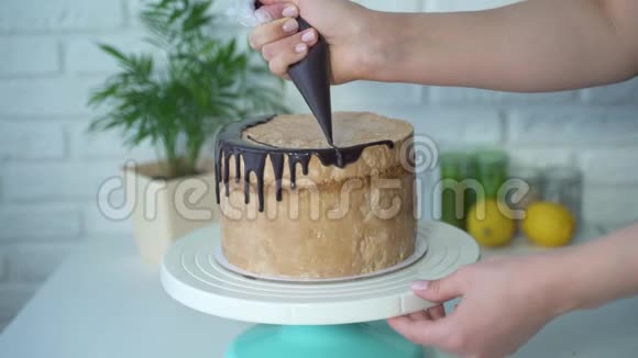 一位女糕点厨师从糕点袋中装饰蛋糕涂上巧克力奶油视频的预览图