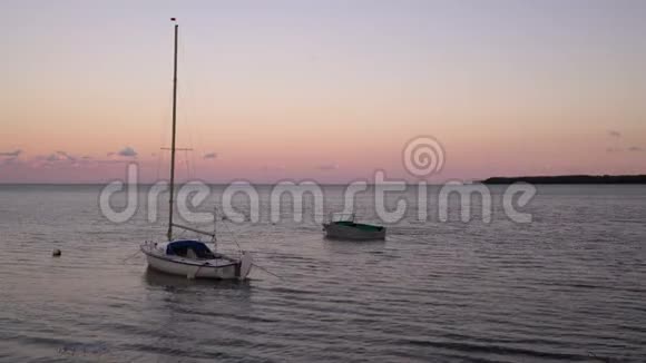 日落时分渔船在码头靠岸停靠水上游艇背景是五彩缤纷的晚霞视频的预览图