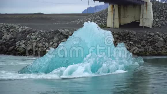 冰岛约库萨尔隆冰川泻湖一大块融化的冰块向海洋漂浮视频的预览图