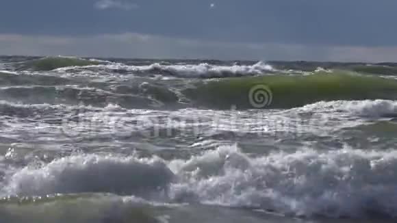 在大海中破浪前行危险的海浪与泡沫撞击附近的海滩即将到来的潮汐视频的预览图