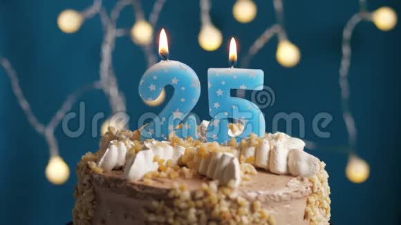 生日蛋糕有25个数字蜡烛在蓝色的背景上蜡烛吹灭了慢动作和特写视频的预览图