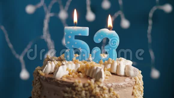 生日蛋糕蓝色背景上有53支蜡烛蜡烛吹灭了慢动作和特写视频的预览图