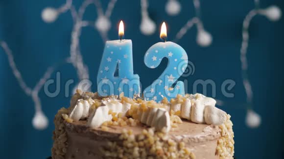 生日蛋糕蓝色背景上有42支蜡烛蜡烛吹灭了慢动作和特写视频的预览图