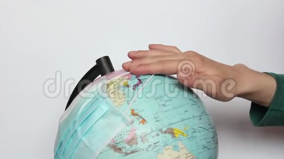 女性双手戴着地球仪上的医疗面罩视频的预览图