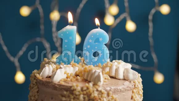 生日蛋糕蓝色背景上有16支蜡烛蜡烛吹灭了慢动作和特写视频的预览图