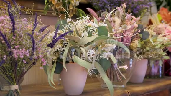 鲜花店出售的花束上面有五颜六色的干花和树叶视频的预览图