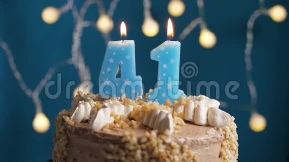 生日蛋糕蓝色背景上有41支蜡烛蜡烛吹灭了慢动作和特写视频的预览图