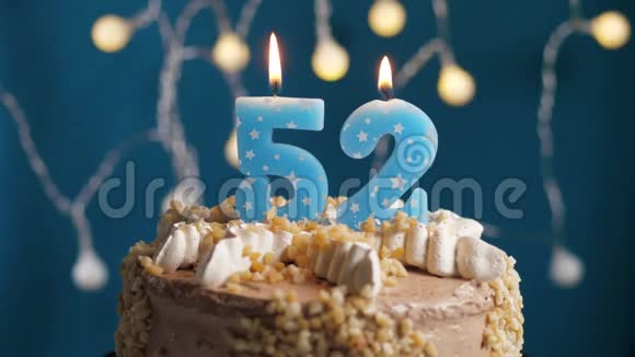 生日蛋糕蓝色背景上有52支蜡烛蜡烛吹灭了慢动作和特写视频的预览图