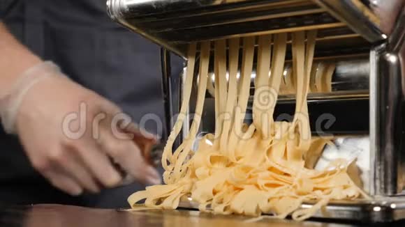 传统的意大利自制面食正在机器上切割面团新鲜意大利面的慢动作食物片段视频的预览图