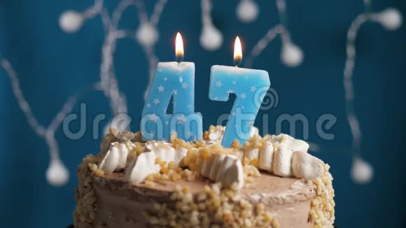 生日蛋糕蓝色背景上有47支蜡烛蜡烛吹灭了慢动作和特写视频的预览图