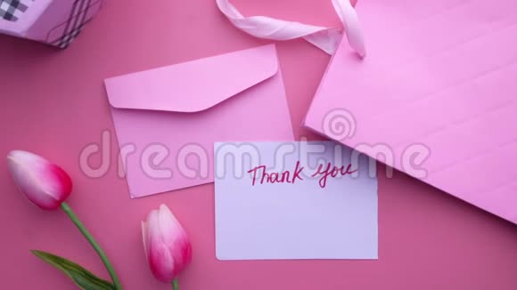 粉色背景的感谢信和礼品盒的俯视图视频的预览图