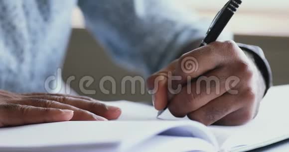 非洲左撇子商人在组织者手里拿着笔写作关门视频的预览图