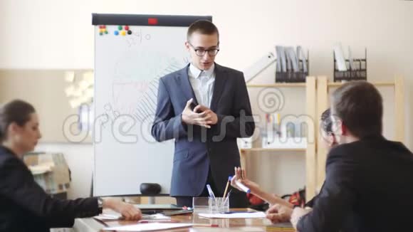 不确定的年轻人穿着夹克和眼镜说会议前的工作报告视频的预览图