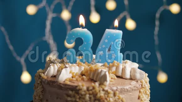 生日蛋糕蓝色背景上有34支蜡烛蜡烛吹灭了慢动作和特写视频的预览图