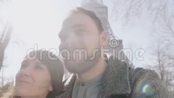 亲密的幸福夫妇在巴黎埃菲尔铁塔附近拥抱和亲吻约会和家庭概念慢动作视频的预览图