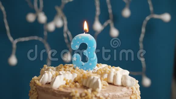 生日蛋糕蓝色背景上有3支蜡烛蜡烛吹灭了慢动作和特写视频的预览图