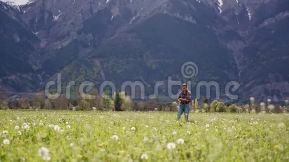 少妇采野花在风景秀丽的山景上织蒲公英花环总计划视频的预览图
