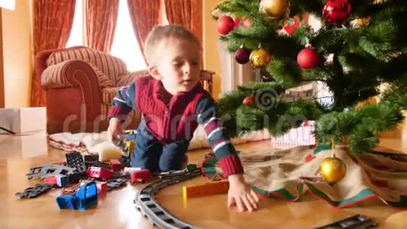 小男孩的4k视频收到玩具铁路和火车圣诞节从圣诞老人儿童建筑栏杆视频的预览图