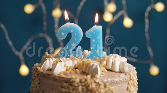 生日蛋糕蓝色背景上有21支蜡烛蜡烛吹灭了慢动作和特写视频的预览图