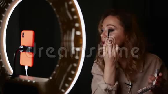 漂亮的女化妆师用眼影坐在环形灯光前视频的预览图