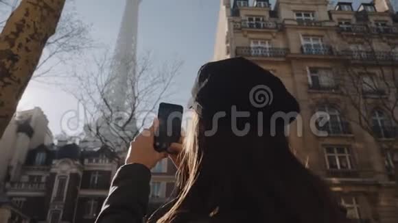 后景快乐美丽的旅游女性在巴黎观看艾菲尔铁塔的智能手机视频分享在线慢动作视频的预览图