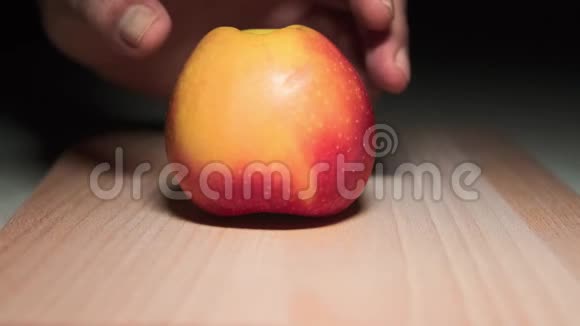 特写切片苹果一个男人在厨房的砧板上切红苹果视频的预览图
