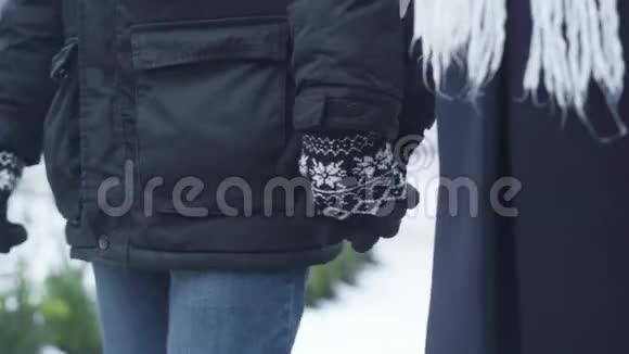 特写男女双手在冬季手套中相握男人和女人在户外散步休闲视频的预览图