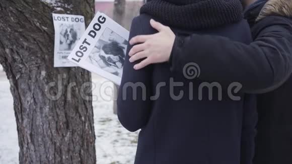 背面的观点不可辨认的白人男女拥抱在树前与失踪的狗广告绝望的圣视频的预览图