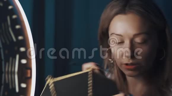 女人的美丽vlogger在她的眉毛前用小刷子在环光视频的预览图